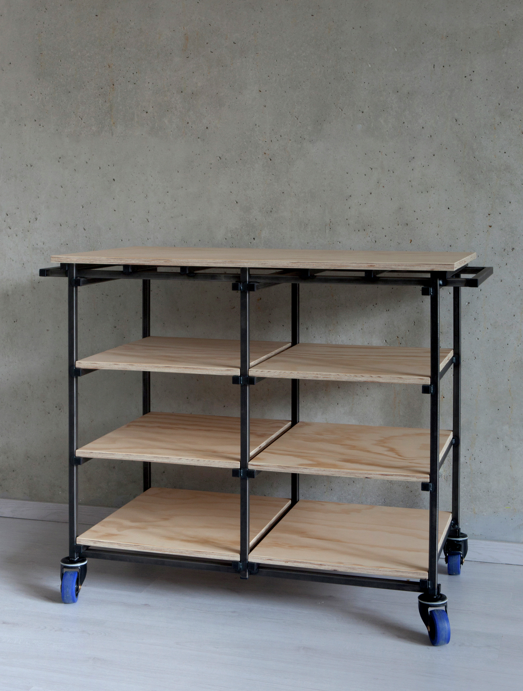 Trolley on wheels made from metal bars and plywood shelves with transparent coating.